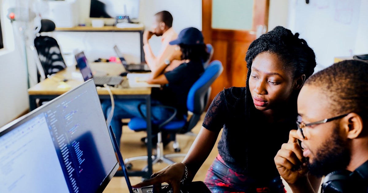 woman and man sitting in front of monitor