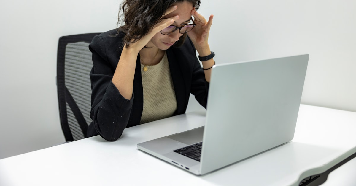 a woman sitting in front of a laptop computer