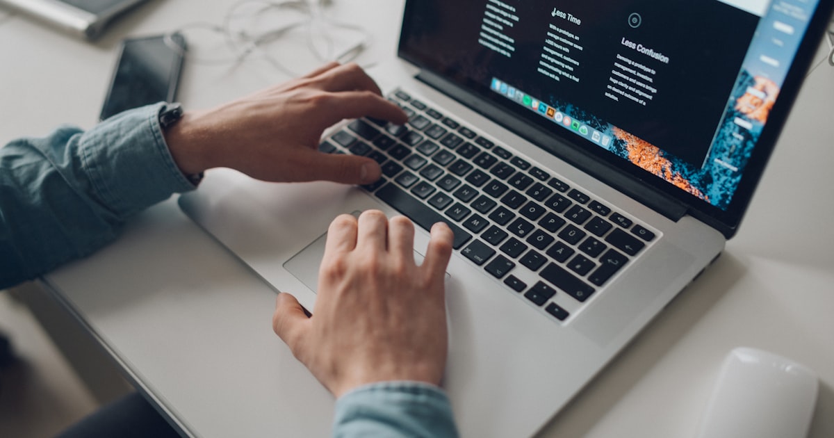 person wearing long-sleeve top working on laptop